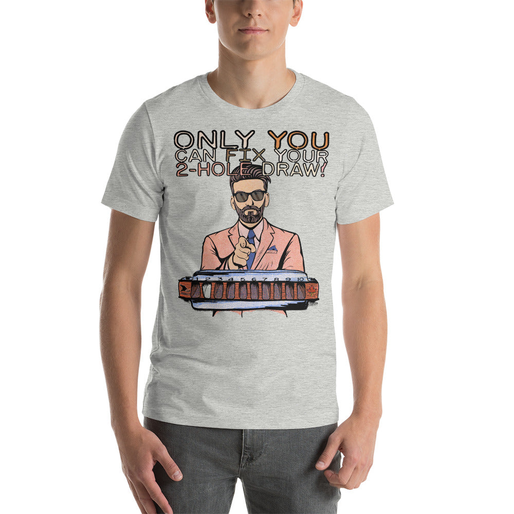 A male model wearing the heather grey version of the T-Shirt. The shirt reads, "Only YOU can fix your 2-hole draw!" Under this text is a man in sunglasses and a pink suit and tie, pointing forward, above a harmonica with a blank space in the 2-hole.